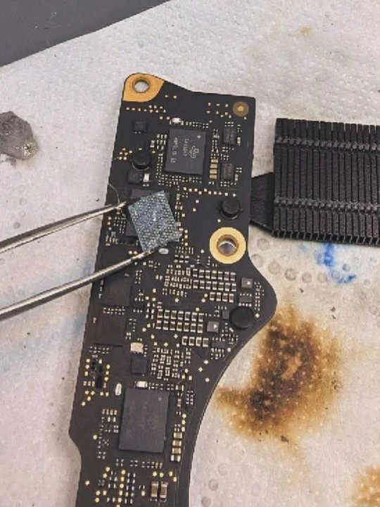 MacBook logic board micro-soldering under microscope during board-level repair in Dubai — MacTech Pro