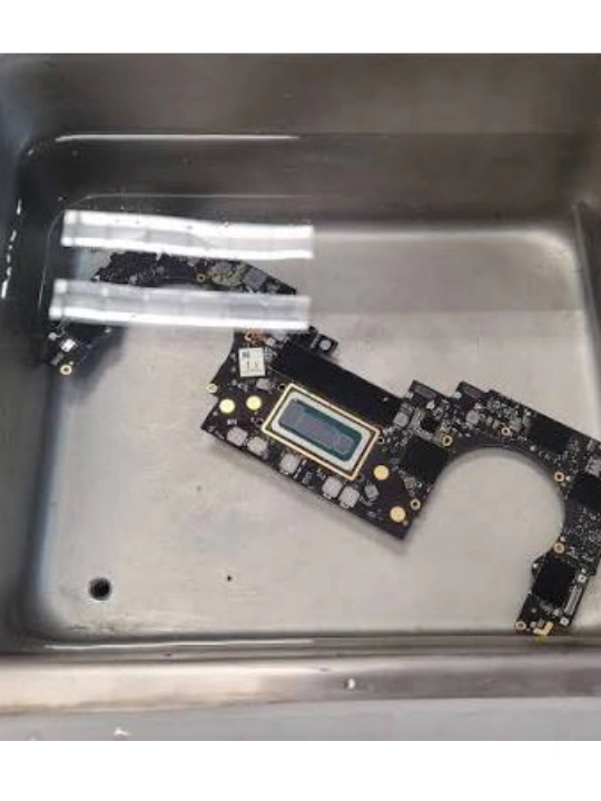 Ultrasonic cleaning of a water-damaged MacBook logic board in Dubai — MacTech Pro
